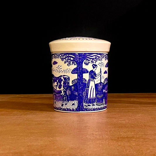 The Fine Cheese Company Potted Stilton in a blue-and-white illustrated pot on a wooden surface